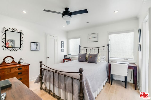 bedroom with light hardwood / wood-style floors, ornamental molding, and ceiling fan