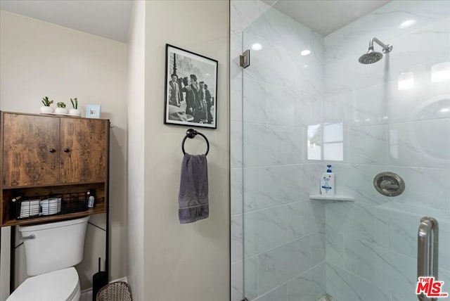 bathroom with a shower with shower door and toilet