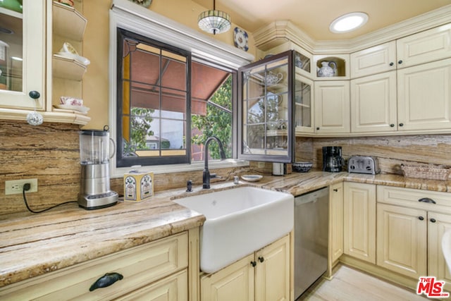 kitchen featuring light stone countertops, dishwasher, tasteful backsplash, and sink