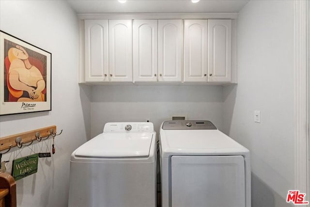 clothes washing area with cabinets and independent washer and dryer