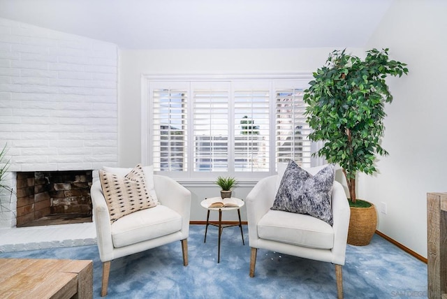 living area featuring carpet floors and a large fireplace