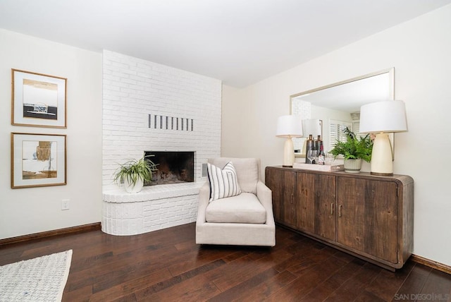 living area with a fireplace and dark wood-type flooring