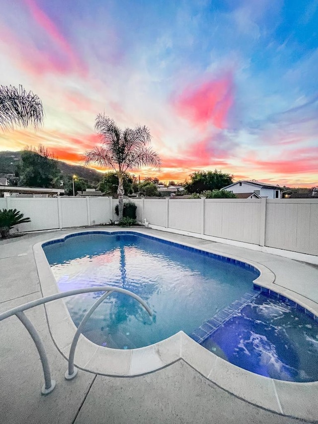 view of pool at dusk