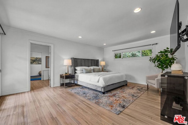 bedroom with light hardwood / wood-style floors and crown molding