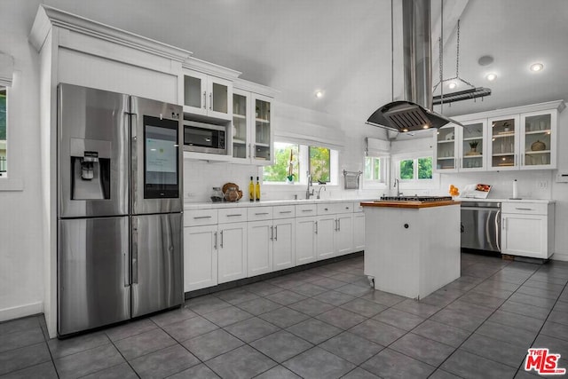 kitchen featuring white cabinets, a center island, island exhaust hood, and stainless steel appliances