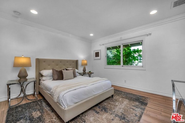 bedroom with wood-type flooring and ornamental molding