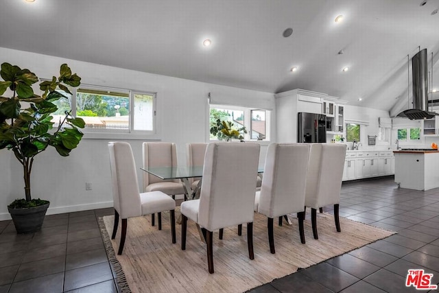 tiled dining space featuring a healthy amount of sunlight, lofted ceiling, and sink