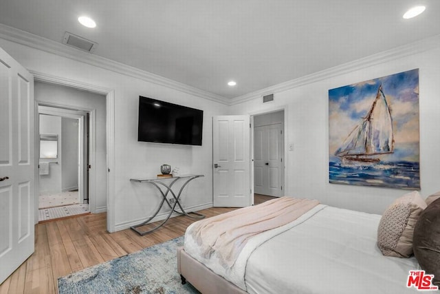 bedroom with hardwood / wood-style flooring and crown molding