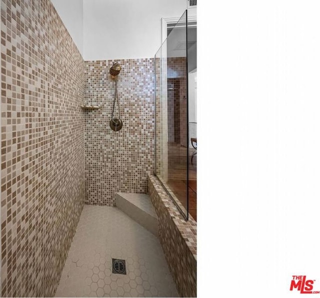 bathroom featuring tile walls and tiled shower