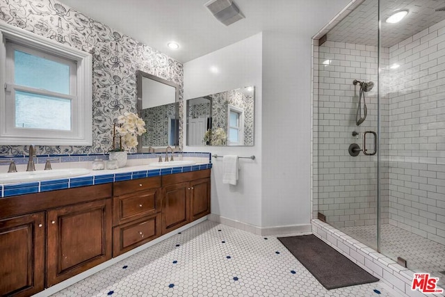 bathroom featuring tile patterned flooring, vanity, and walk in shower