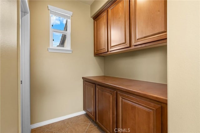 unfurnished office featuring light tile patterned floors and baseboards