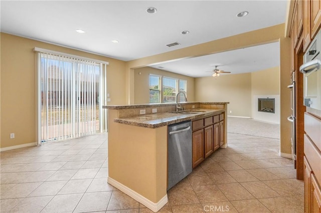 kitchen with stainless steel appliances, visible vents, brown cabinetry, open floor plan, and a sink