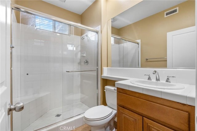 full bathroom with toilet, a stall shower, visible vents, and vanity