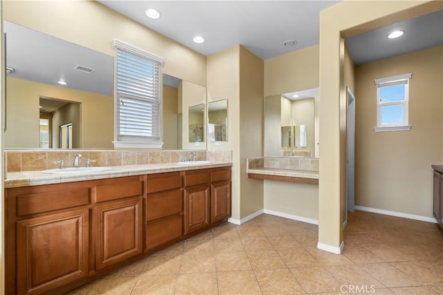 full bathroom with baseboards, a sink, visible vents, and double vanity