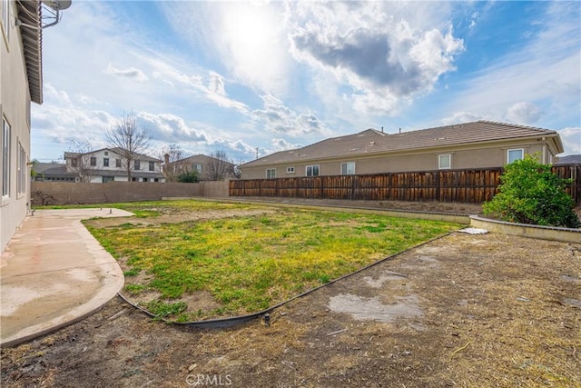 view of yard featuring a fenced backyard and a residential view