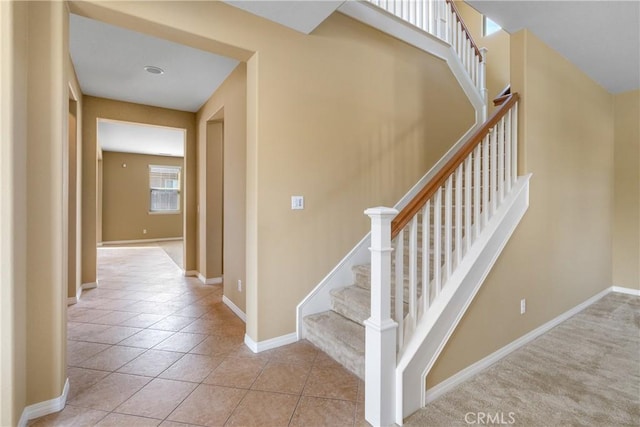 stairway featuring tile patterned flooring and baseboards