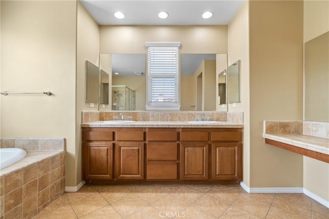 full bath with double vanity, a sink, a bath, and tile patterned floors