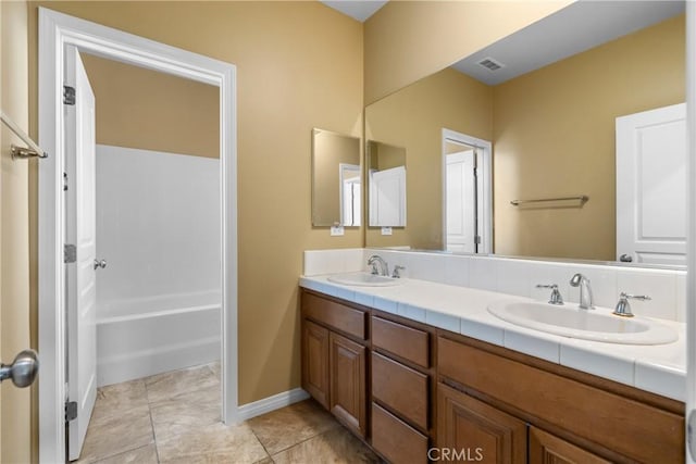 full bath with double vanity, baseboards, visible vents, and a sink