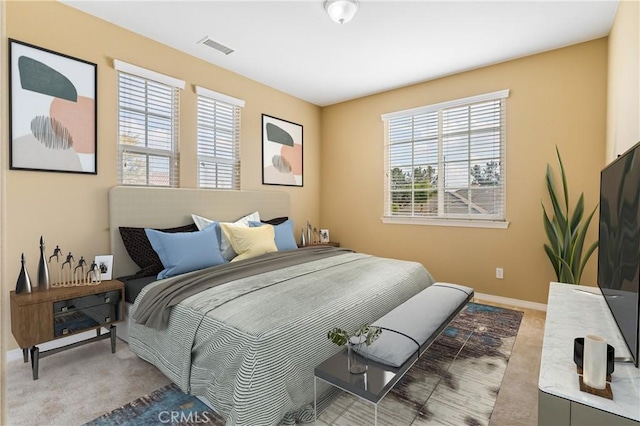 bedroom featuring light carpet, baseboards, and visible vents