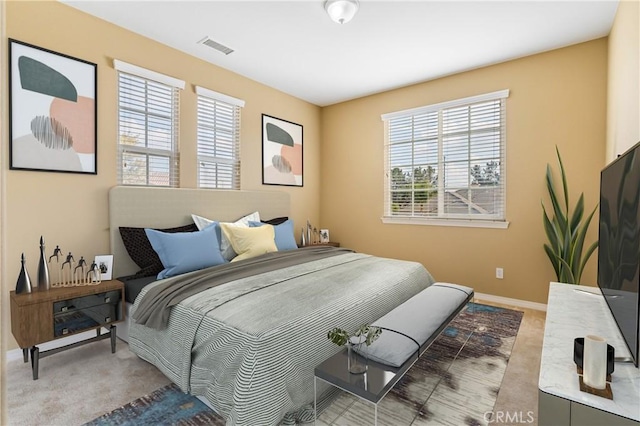 carpeted bedroom with baseboards and visible vents