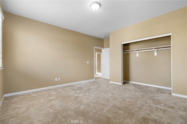 unfurnished bedroom with baseboards, a closet, and light colored carpet