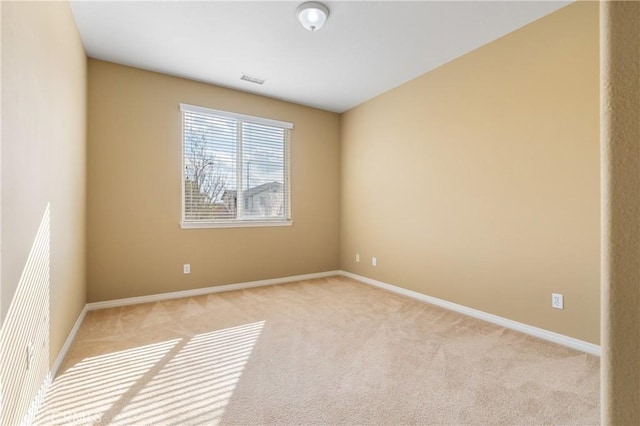 unfurnished room featuring light carpet and baseboards