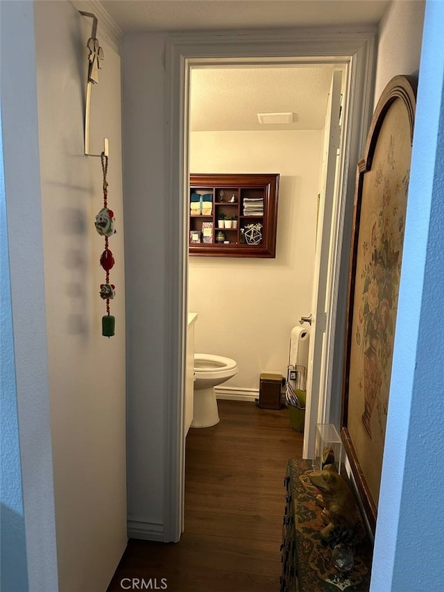 hall with a textured ceiling and dark hardwood / wood-style floors