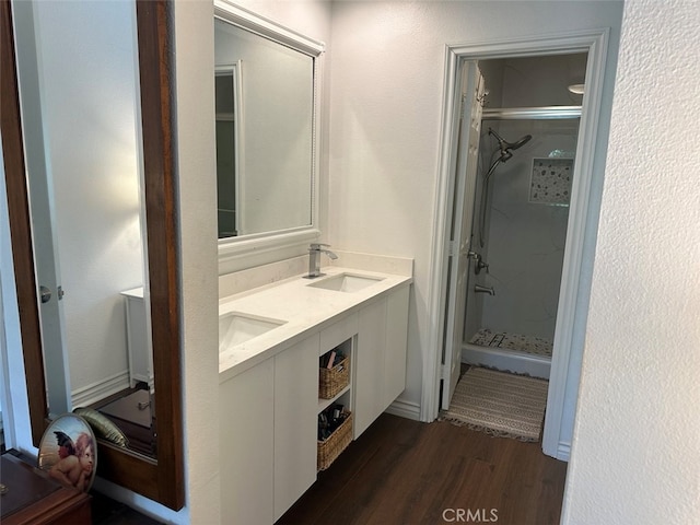 bathroom featuring vanity, wood-type flooring, and tiled shower