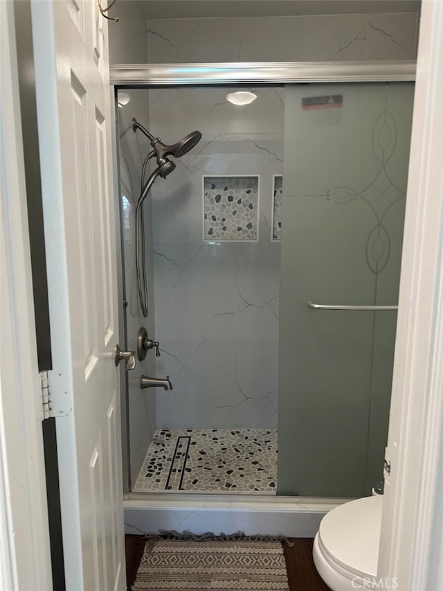 bathroom featuring toilet and a tile shower