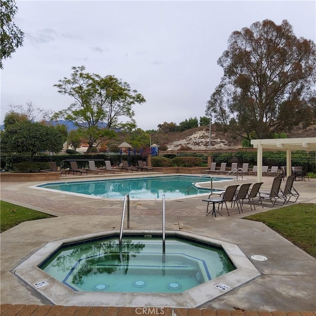 view of swimming pool with a community hot tub and a patio