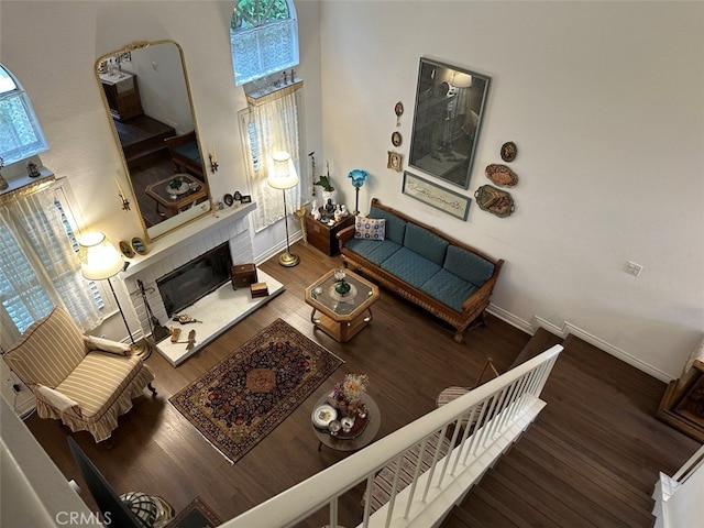 living room with a tile fireplace and hardwood / wood-style floors