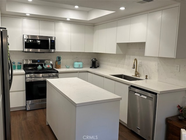 kitchen with a center island, sink, white cabinetry, and stainless steel appliances