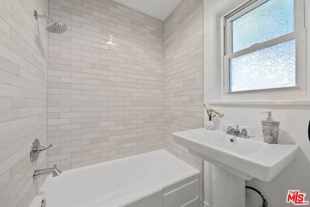 bathroom with tiled shower / bath combo and sink