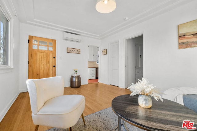 living area featuring light hardwood / wood-style floors and a wall mounted AC