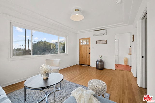 living room featuring light wood-type flooring and a wall unit AC