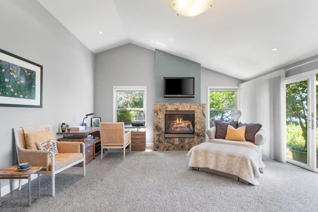 living area with carpet, lofted ceiling, and a high end fireplace