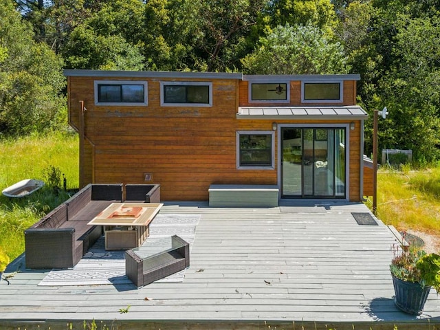 deck featuring an outdoor living space with a fire pit