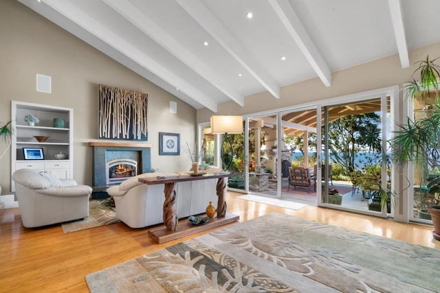 living room with beam ceiling, light wood-type flooring, and high vaulted ceiling