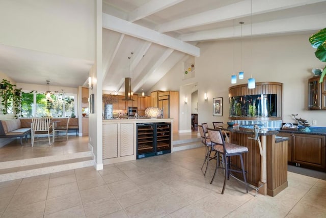 kitchen featuring a kitchen breakfast bar, wine cooler, high vaulted ceiling, and decorative light fixtures