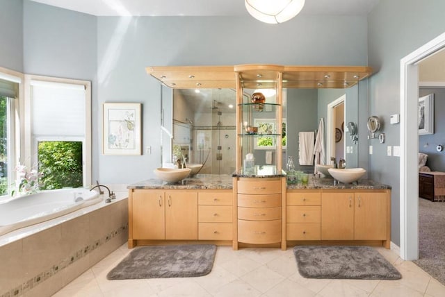 bathroom with tile patterned floors, vanity, and separate shower and tub