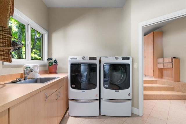 laundry area with washing machine and dryer, light tile patterned floors, and sink