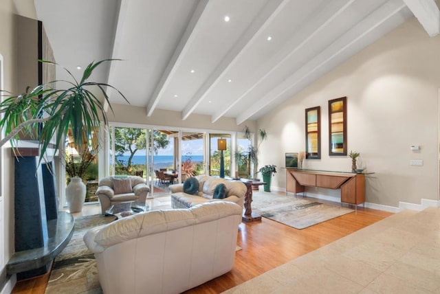 living room featuring vaulted ceiling with beams, a water view, and light hardwood / wood-style floors