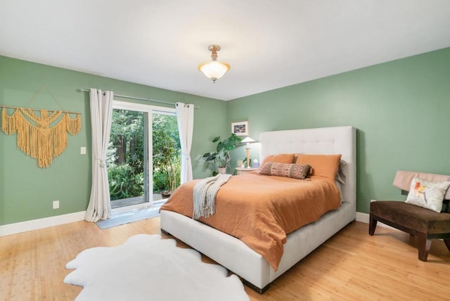 bedroom featuring access to exterior and light wood-type flooring