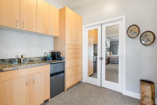 kitchen with light brown cabinets, light colored carpet, and french doors