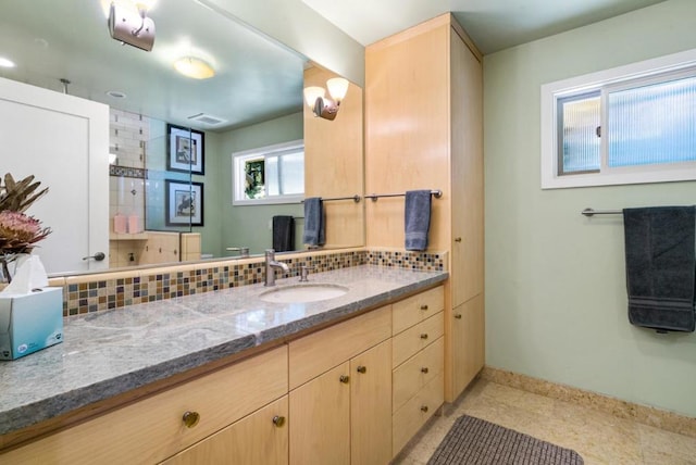 bathroom featuring decorative backsplash, vanity, and a wealth of natural light