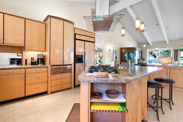 kitchen with light stone countertops, stainless steel gas cooktop, built in fridge, beamed ceiling, and an island with sink