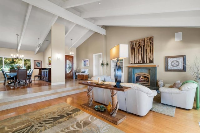 living room featuring a fireplace, beam ceiling, light wood-type flooring, and high vaulted ceiling