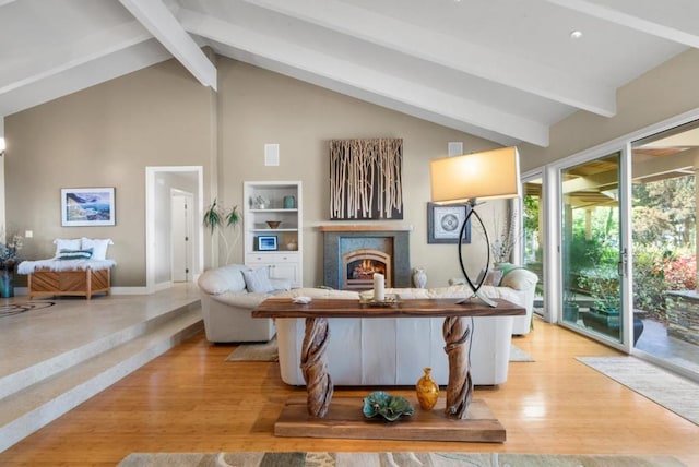 living room with beam ceiling, light hardwood / wood-style floors, and high vaulted ceiling