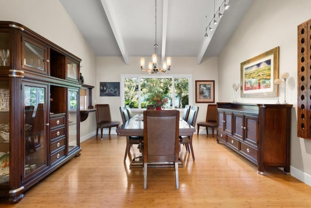 dining room featuring lofted ceiling with beams, an inviting chandelier, and light hardwood / wood-style flooring