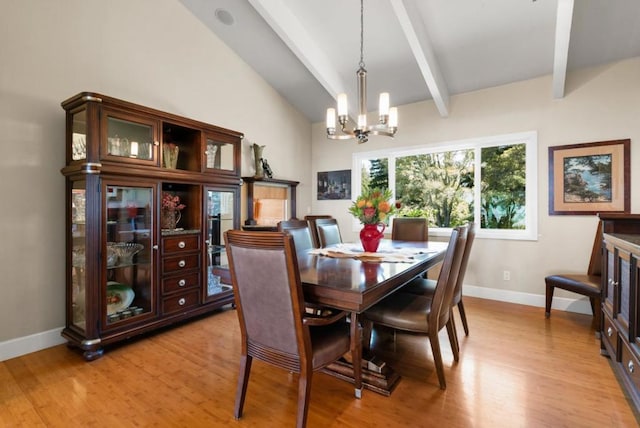 dining area featuring lofted ceiling with beams, light hardwood / wood-style floors, and an inviting chandelier